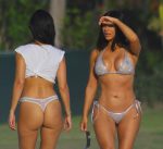 Kim Kardashian shows sexy cleavage and Kourtney Kardashian sexy ass in thong bikini as they take a walk on the beach in Mexico