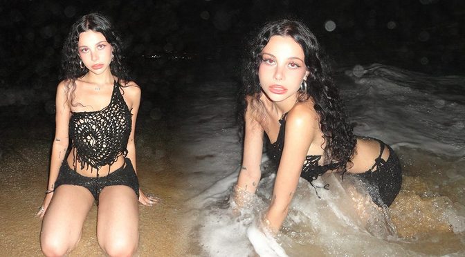 Ellise Gitas Soaked and Stunning in Black Crochet as Waves Crash Around Her Curves